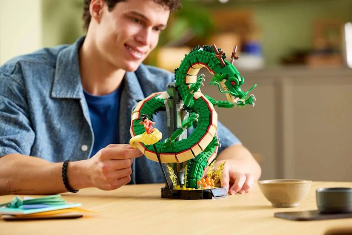 on-foot lifestyle shot of man adjusting dragon build at a wooden table, Shenron & Goku