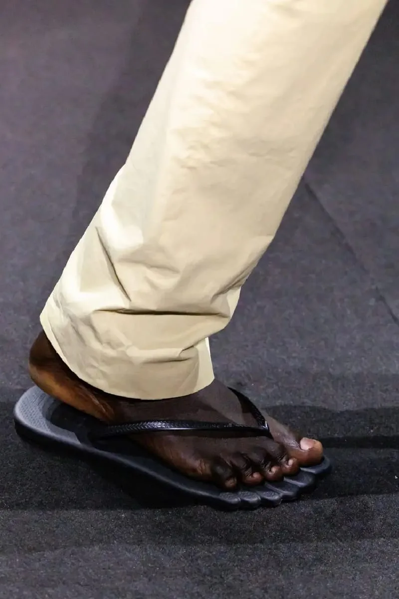 close-up on-foot dark grey ridged toe-shaped sole, black strap, Havaianas Slim 6Toe