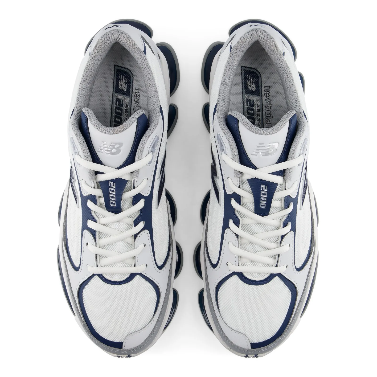 top-down pair, white/navy uppers with '2000' text on tongue and NB insole branding, White/Navy