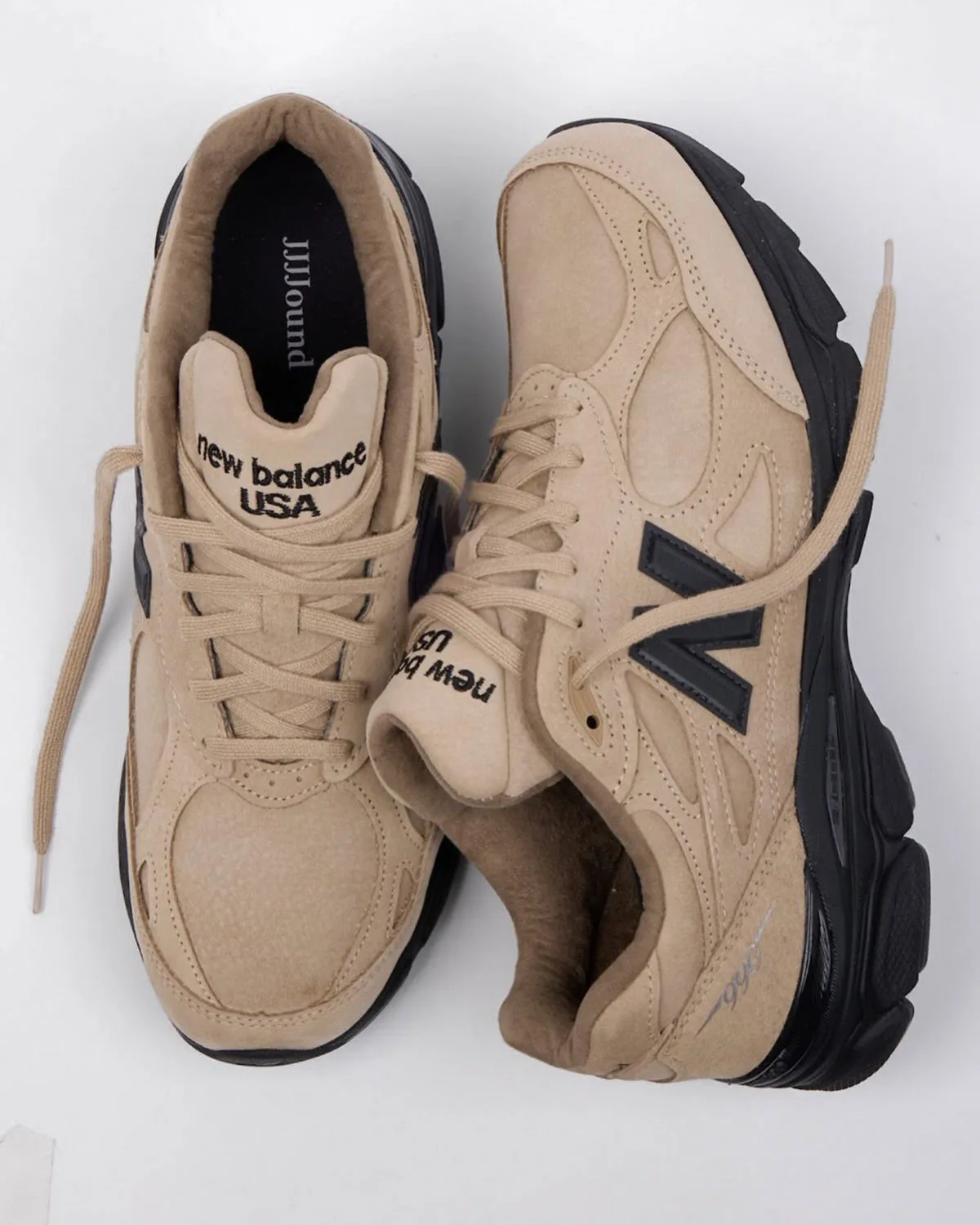 top-down pair view, one shoe flipped showing JJJJound-labeled black insole, Tan Suede