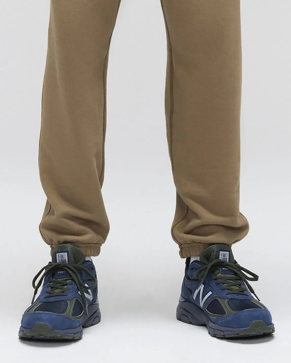 on-foot pair, toe-forward view, navy and olive with white N logo, tan joggers, Made in USA