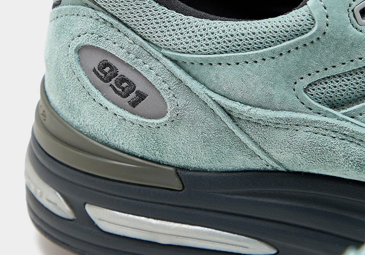 close-up of heel with sage suede, grey 991 oval badge and dark midsole, Green Milieu