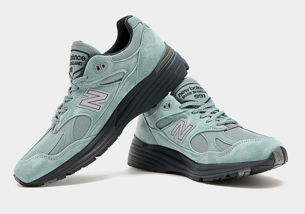 pair crossed showing lateral sides, sage suede with grey N logo and black soles, Green Milieu