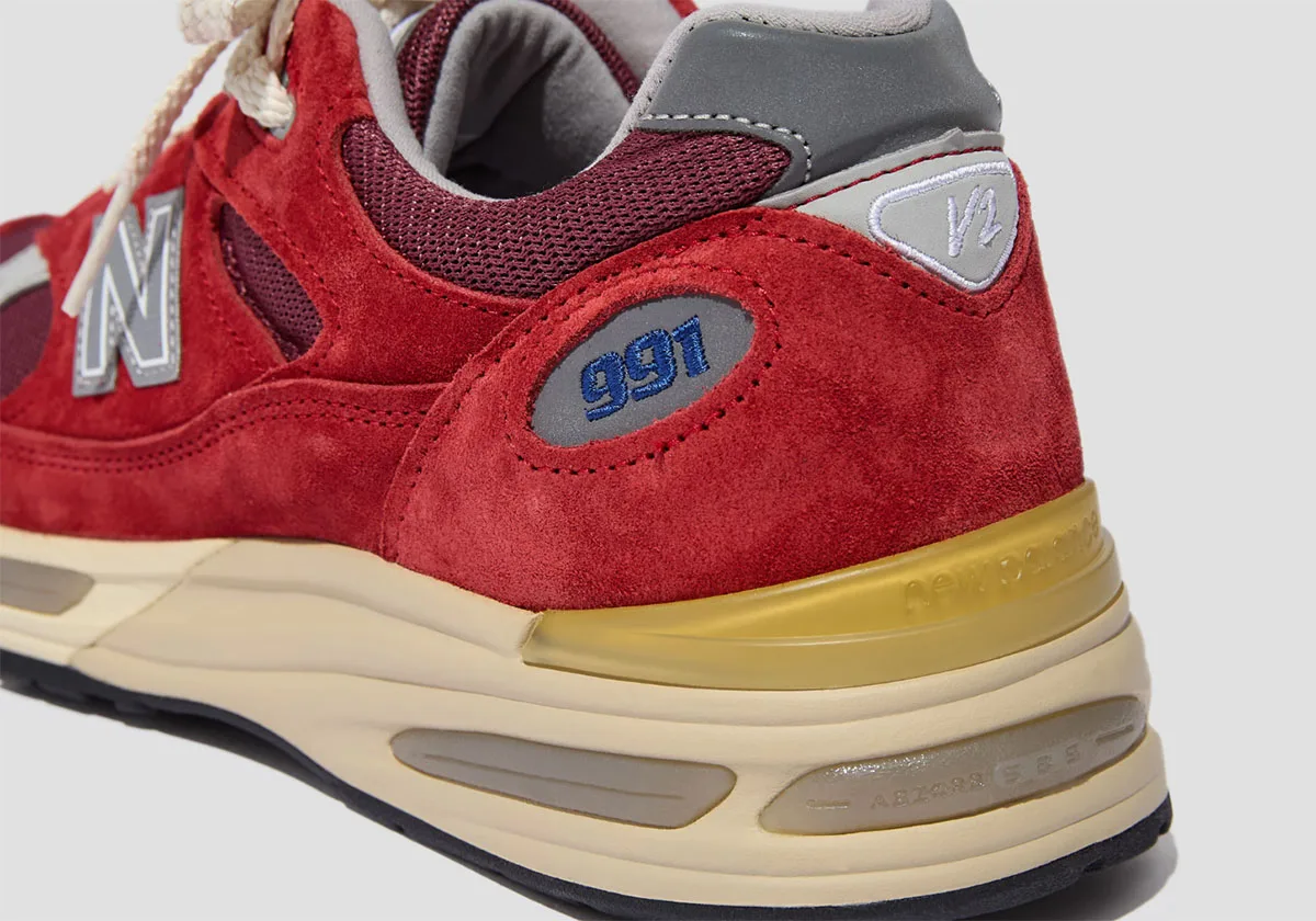 heel close-up, red suede with blue 991 text and gold-tinted midsole panel, Karanda Red