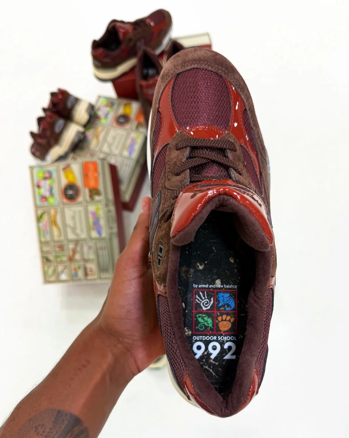 medial tongue close-up in-hand showing outdoor-icon graphic insole and 992 text, Outdoor School