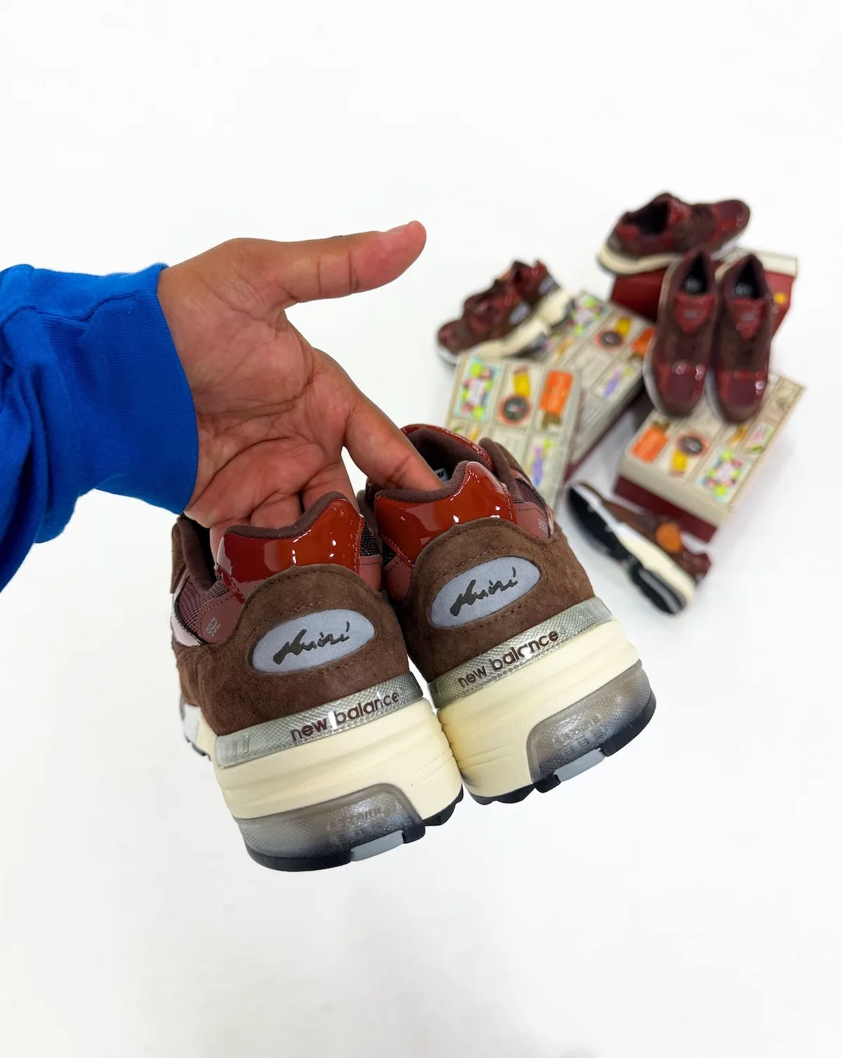 heel close-up in-hand showing suede heel with grey script overlay branding, Outdoor School