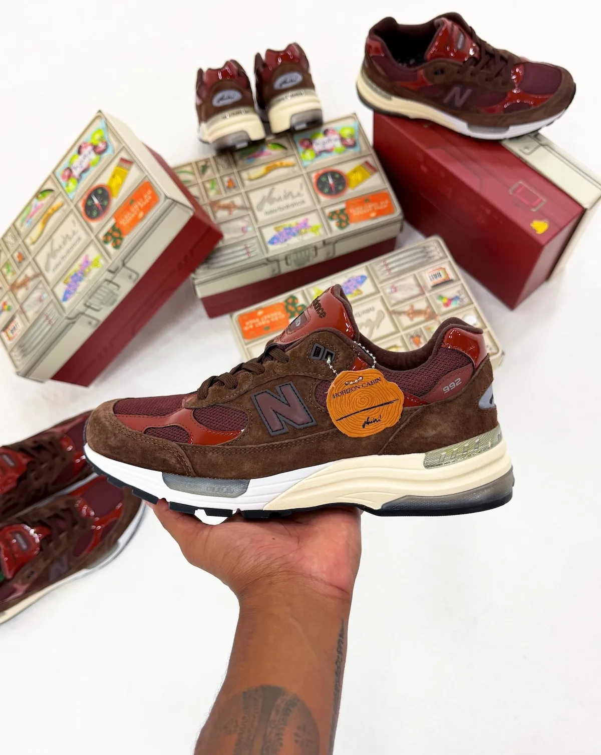 in-hand lateral view with orange wood-slice hang tag, boxes and pairs behind, Outdoor School