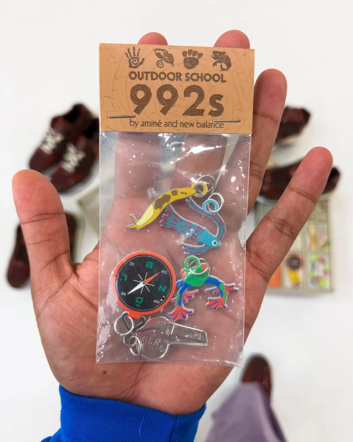 in-hand charm pack with banana slug, bird and frog pendants plus compass keychain, Outdoor School