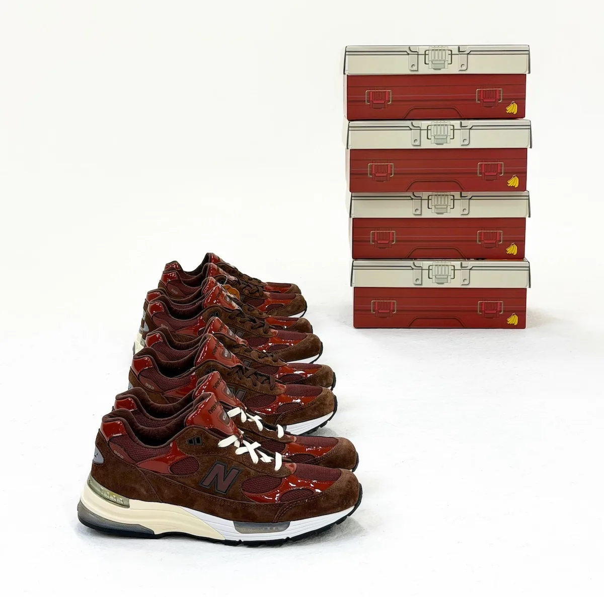 five pairs lined up beside a stack of four red tackle-box style shoe boxes, Outdoor School