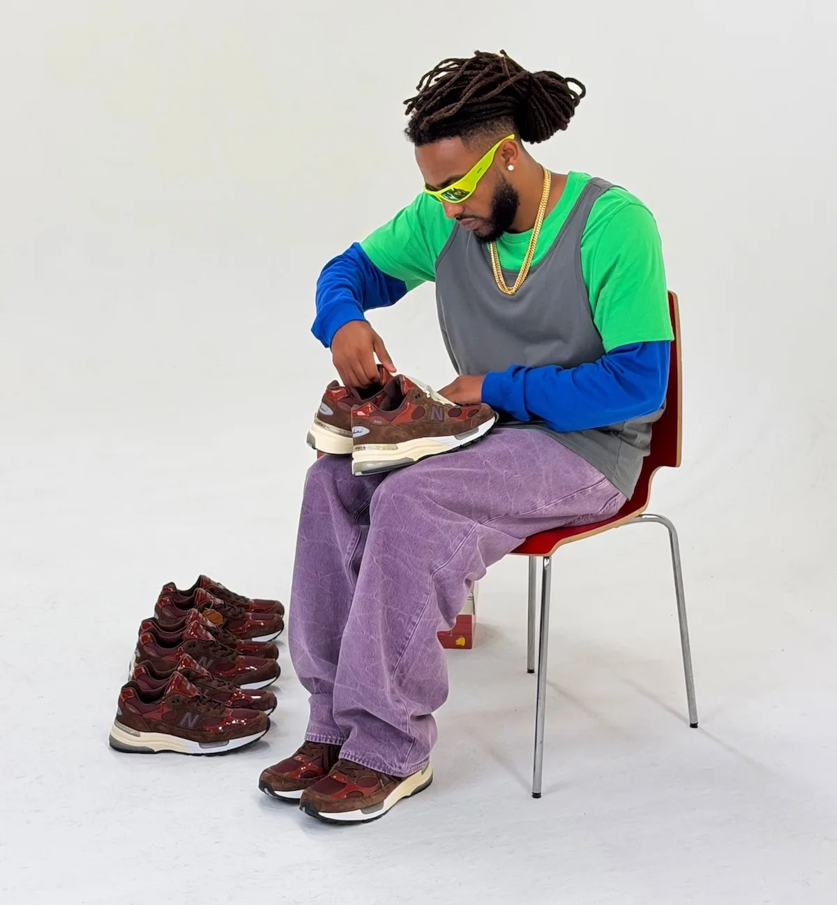 on-foot in-hand, seated model holds pair with a second pair beside boxes, Outdoor School