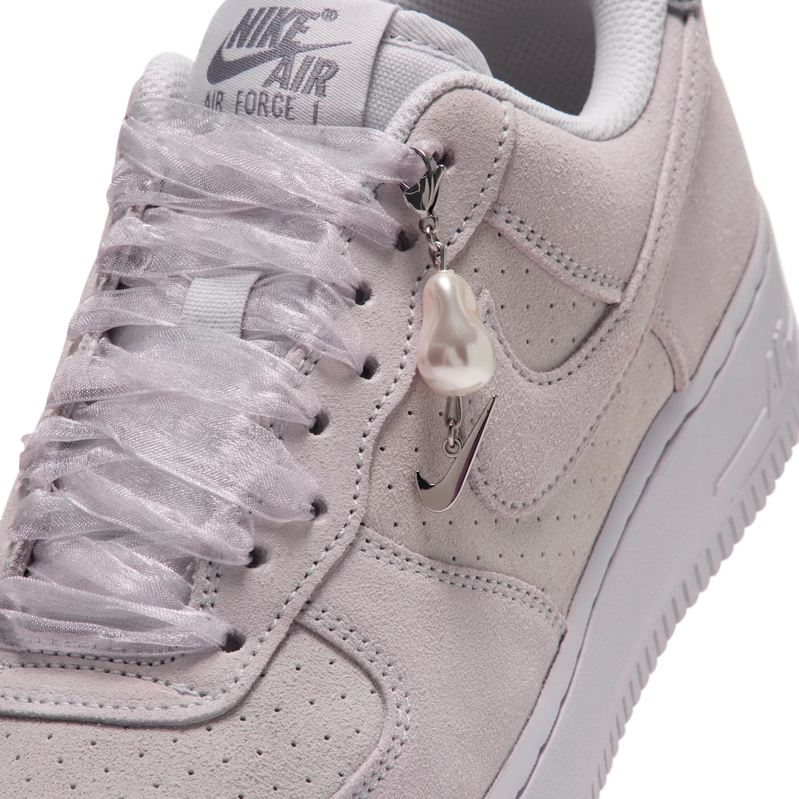 close-up of toe with pearl charm and silver Swoosh clip on the lace, Vast Grey