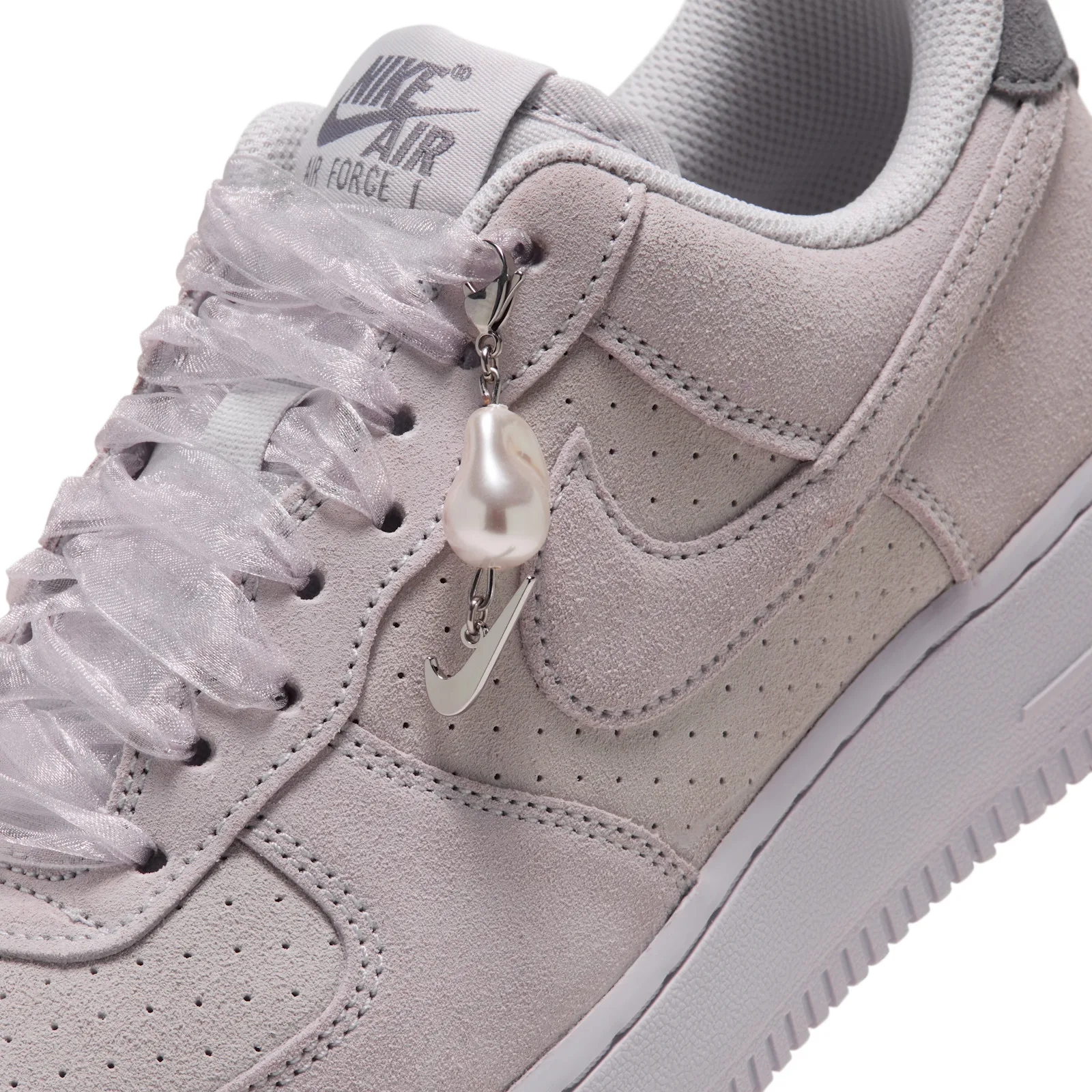 close-up of toe area, pearl charm hanging beside perforated Swoosh, Vast Grey