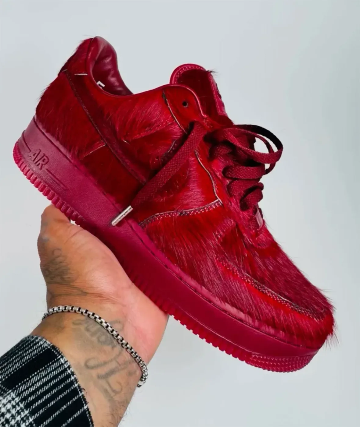 held in-hand, lateral toe-to-heel view of red pony hair texture and midsole AIR text, Team Red