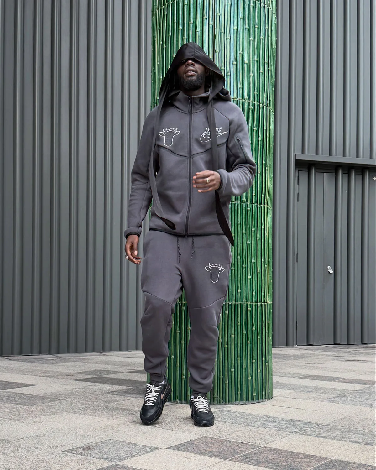 on-foot full view, grey tracksuit with cow-head logo and black pair with white laces, 90 x Wagyu