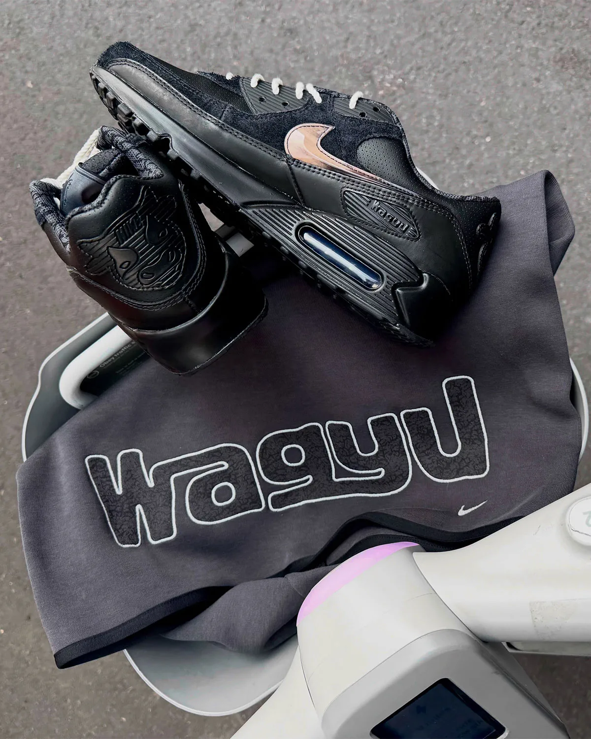 medial and heel pair view, black with bronze swivel swoosh and wagyu heel tab on grey hoodie, Nike Air Max 90 x Wagyu