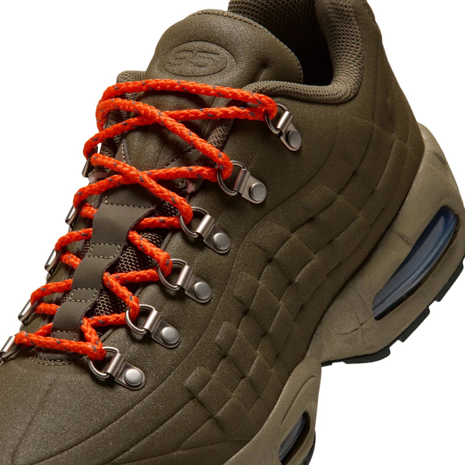 Close-up of orange laces threaded through metal hook eyelets, I 95