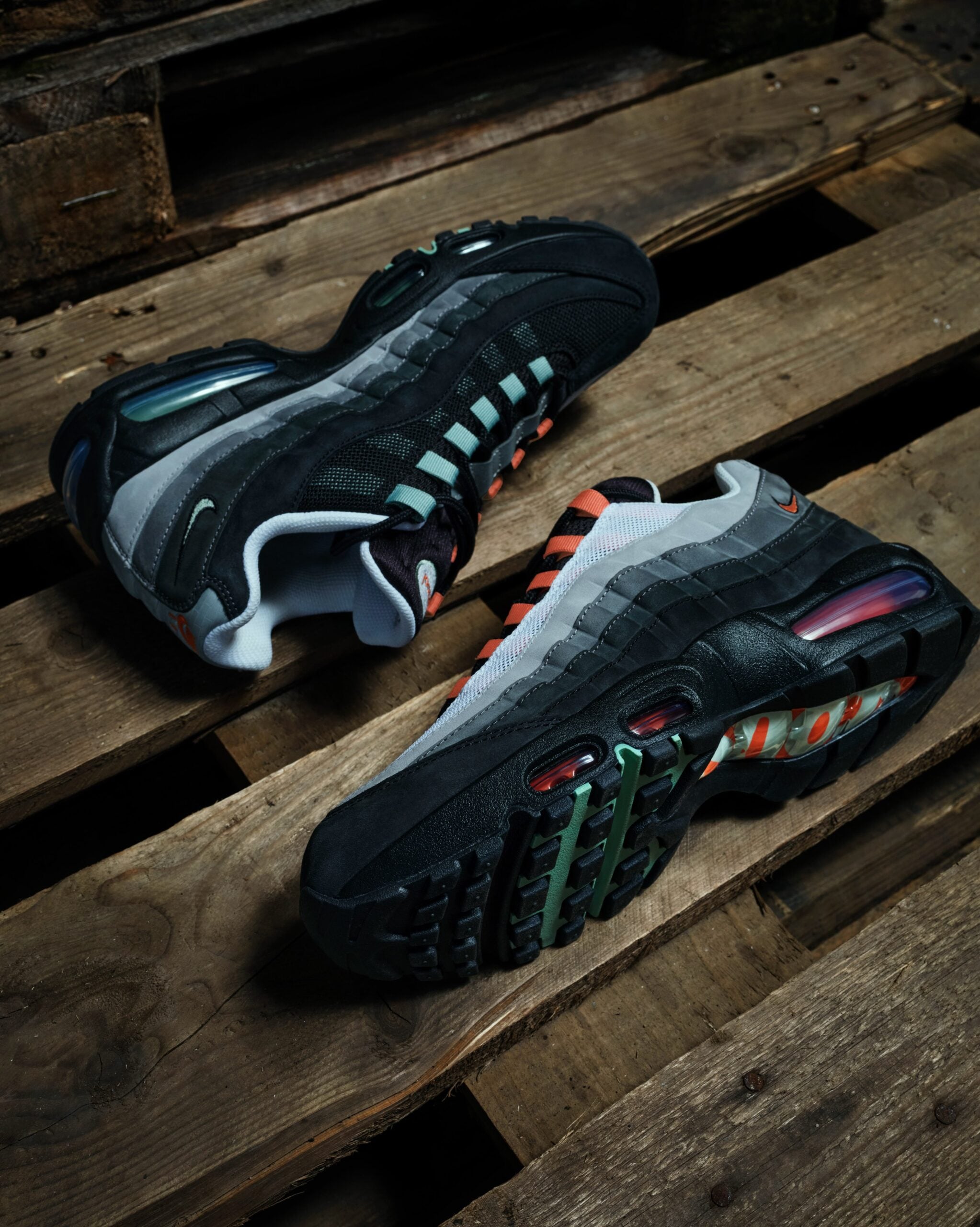 pair angled medial and outsole view, orange Nike swoosh and mint waffle tread on wood, Liverpool