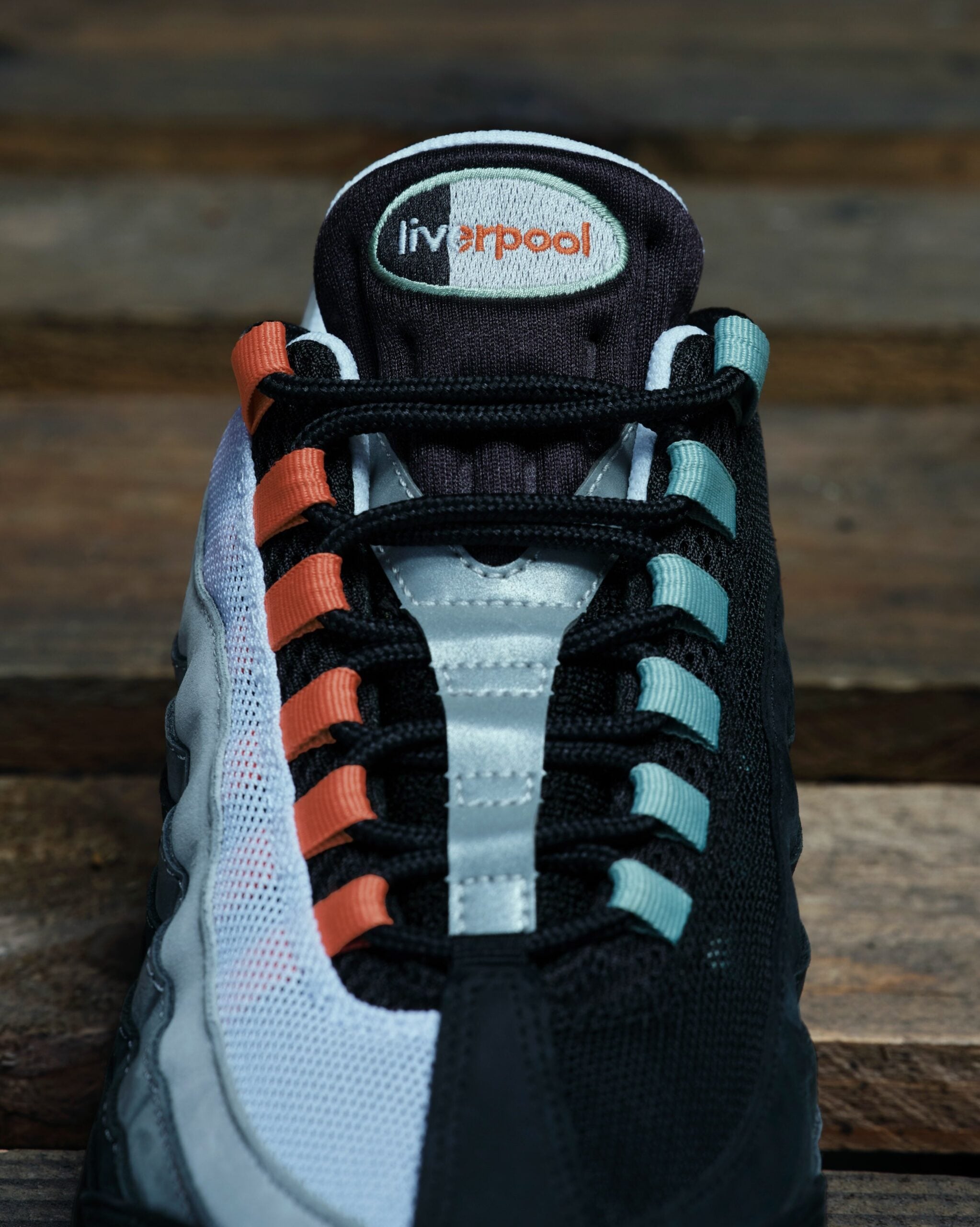 toe box close-up, orange and mint lace loops, black laces and embroidered 'liverpool' tongue tag, Liverpool