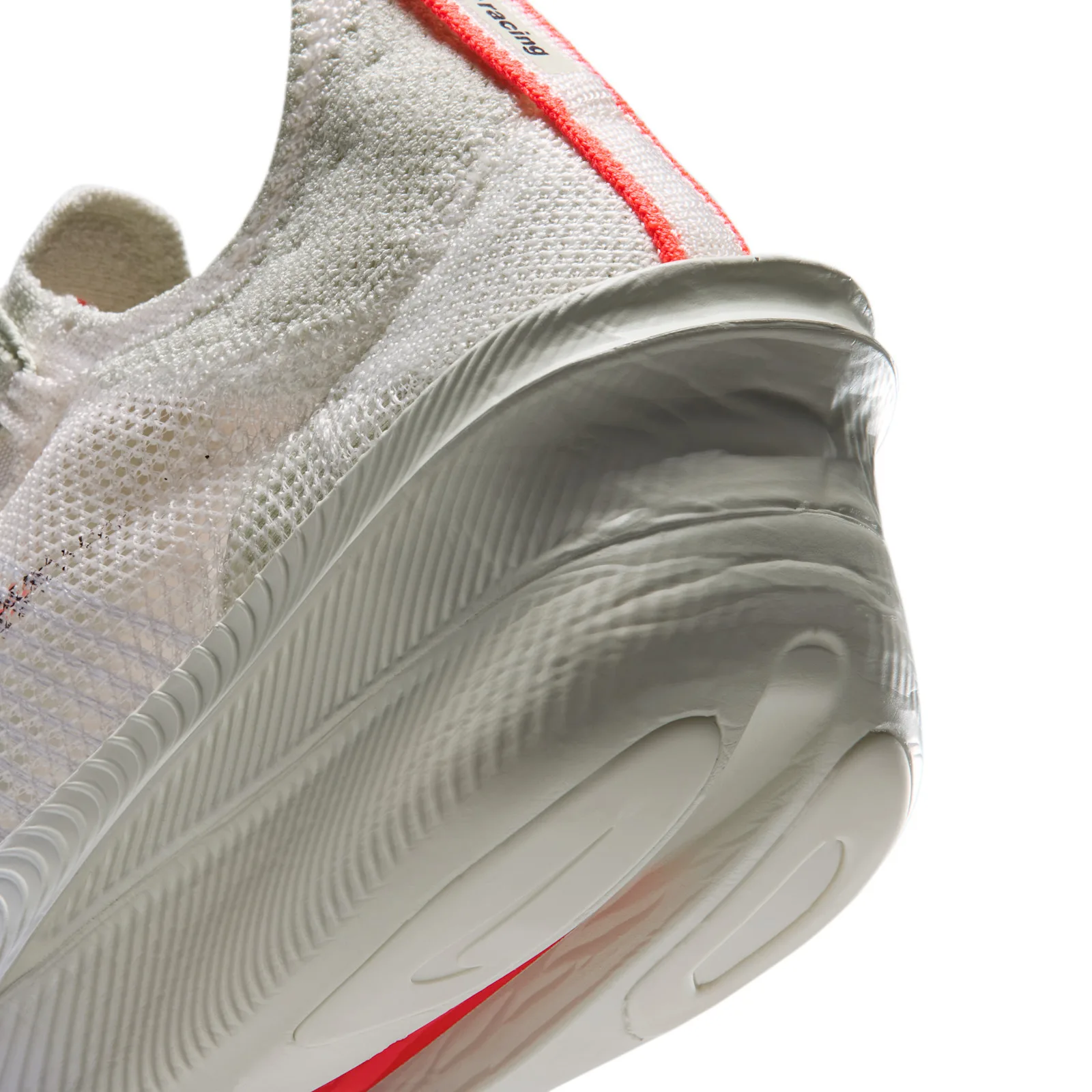 close-up heel and midsole, ribbed white foam wedge with 'racing' text on pull tab, Nike AlphaFly 4