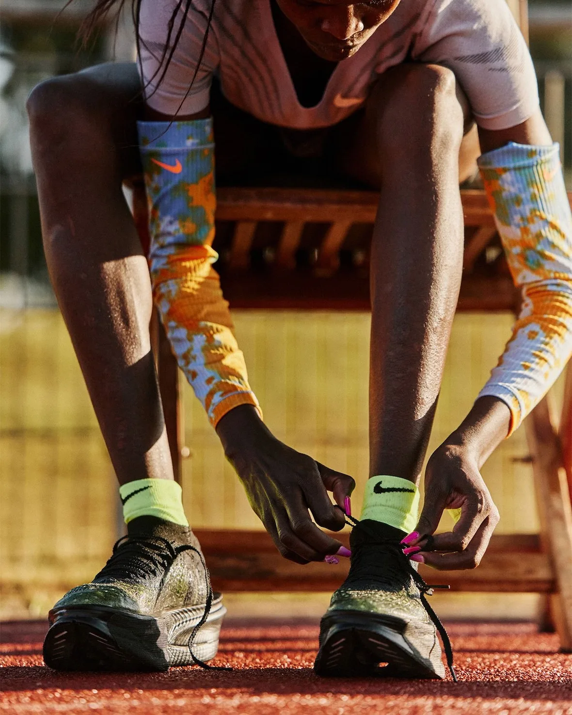 close-up of hands tying black laces, neon socks and colourful leg sleeves, Nike Apex