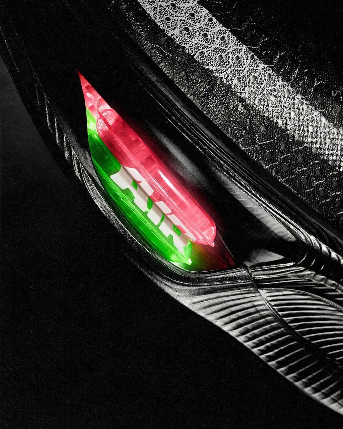 close-up of glowing red and green air unit set into black heel, Nike Apex
