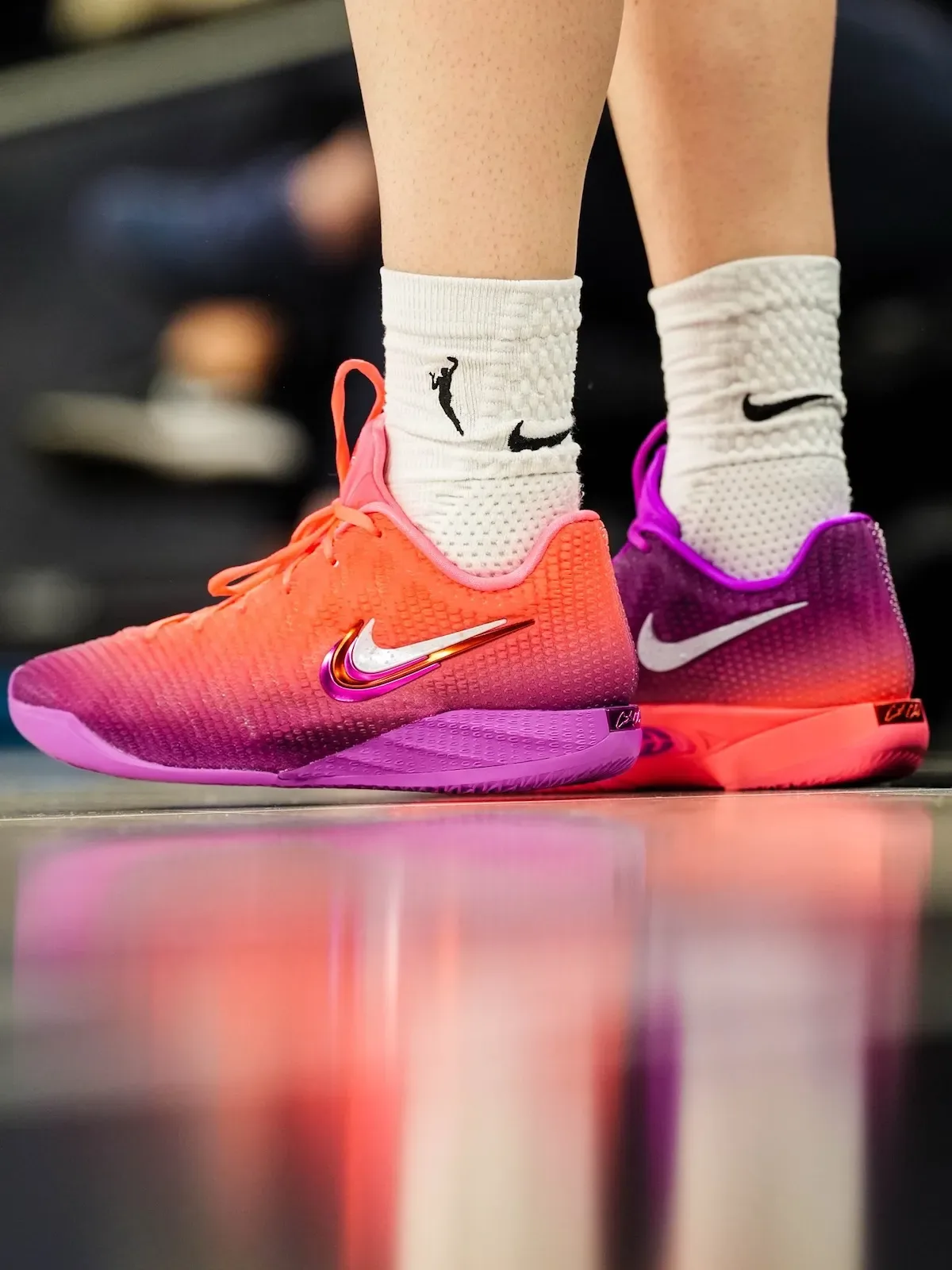 On-foot close-up, orange shoe on left foot, purple shoe on right, white Nike socks, Berry Fade
