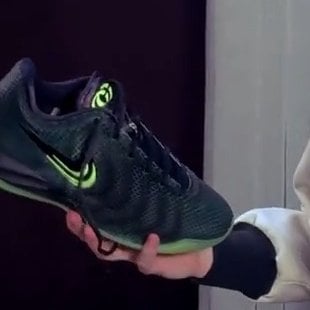in-hand lateral view, black mesh upper with green swoosh and green midsole, Halloween