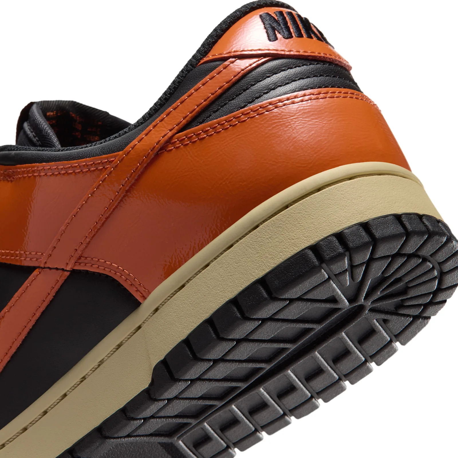 Heel close-up, orange patent leather with black NIKE embroidery, tan midsole, Campfire Orange