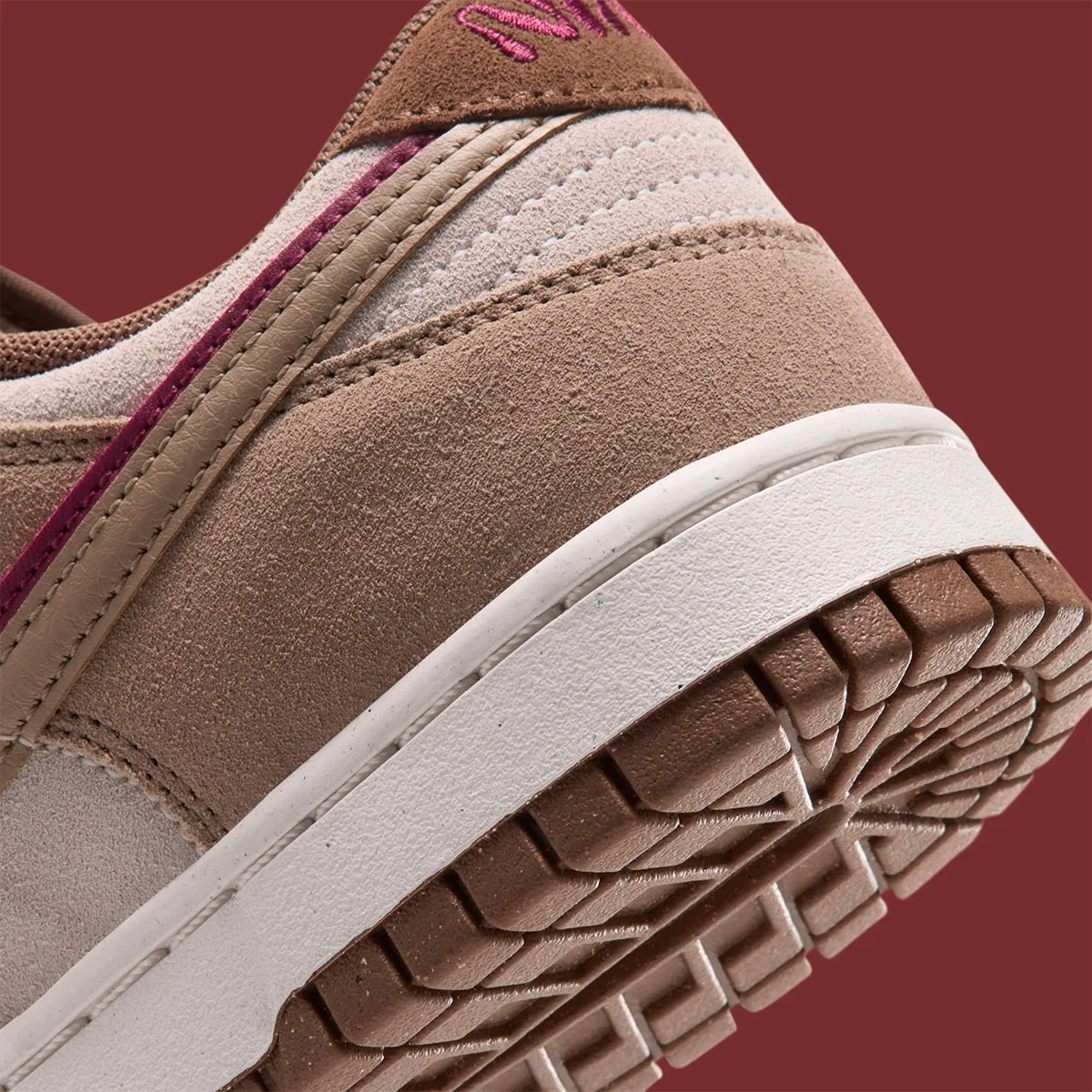 close-up of heel and outsole edge, pink stitching and brown ridged tread, Double Swoosh