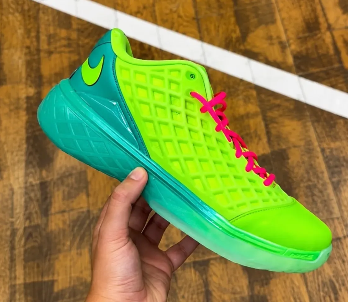 in-hand lateral view, volt upper with teal Nike swoosh and translucent teal outsole, Grinch