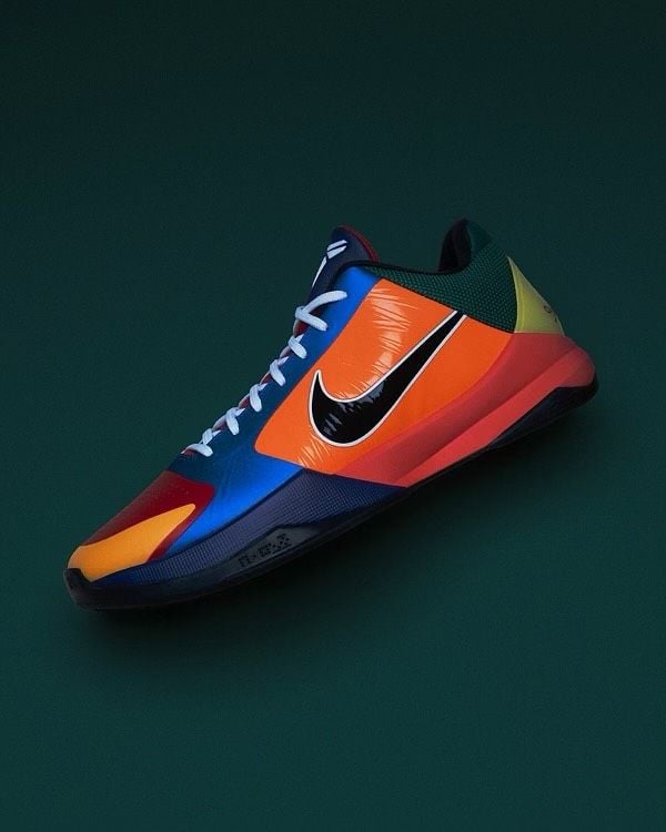 angled toe-lateral view on dark green backdrop, orange swoosh over blue and red panels, What The Rick