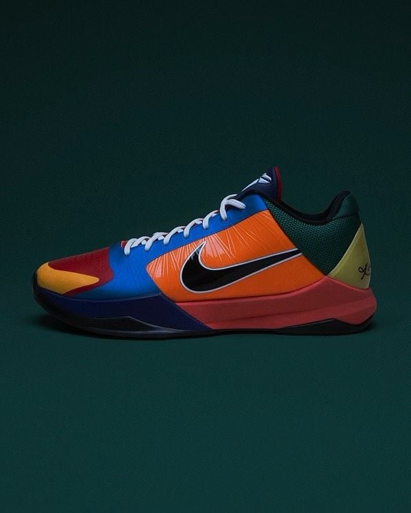 lateral side profile on dark green backdrop, orange upper with black swoosh and navy midsole, What The Rick