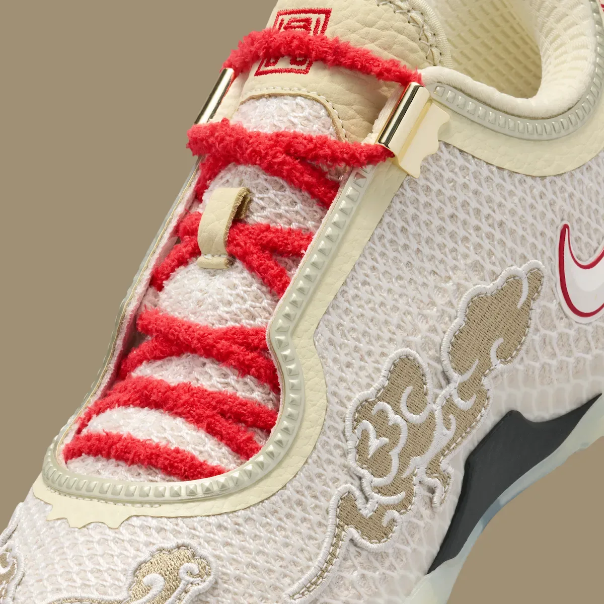close-up of tongue and forefoot, red laces over cream mesh with tan cloud embroidery, Lunar New Year