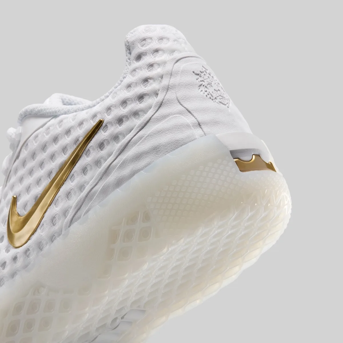 heel close-up, white mesh with gold swoosh and embossed crown crest, LeBron Witness 10