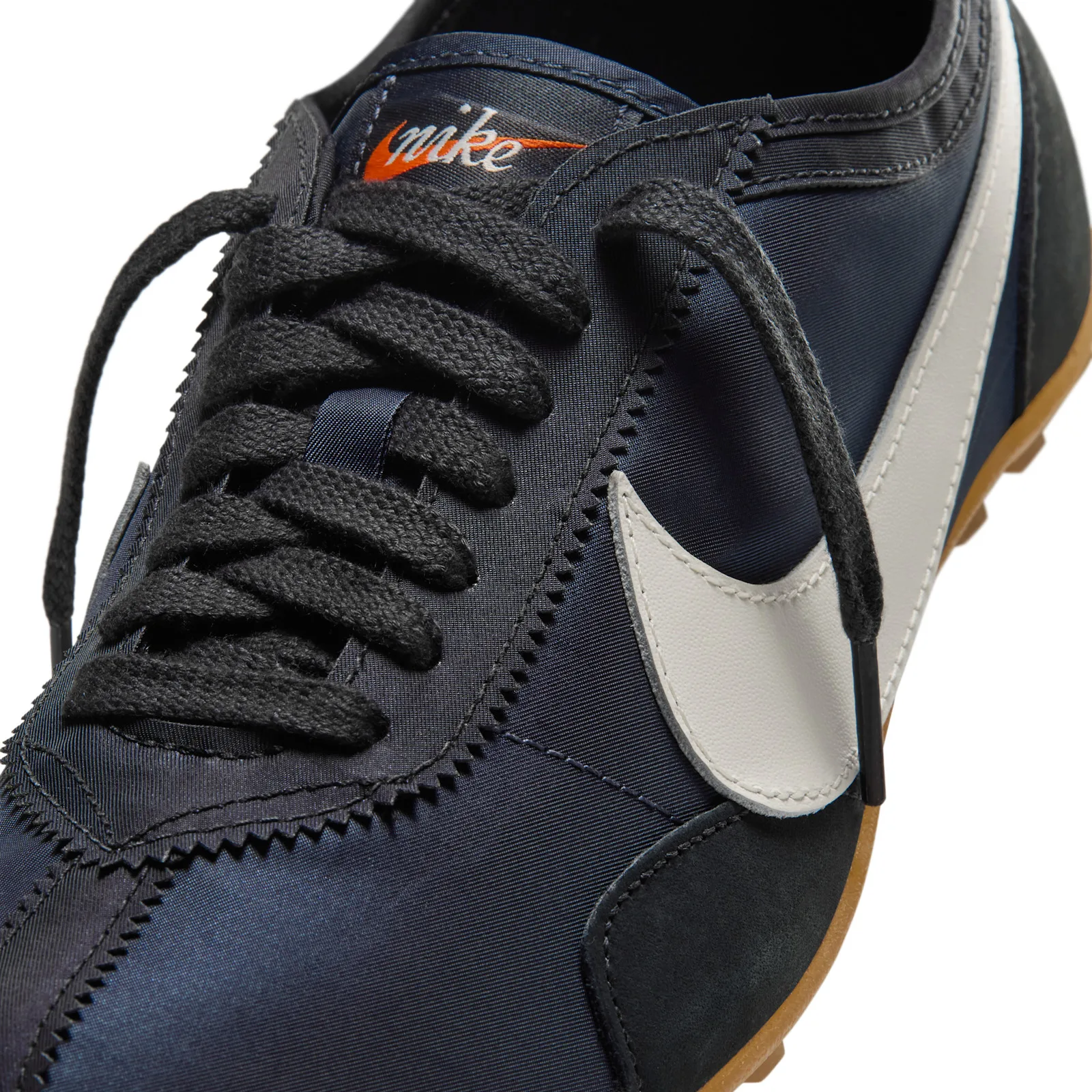 Toe box detail, orange nike wordmark, white swoosh, black laces, gum sole, Off Noir