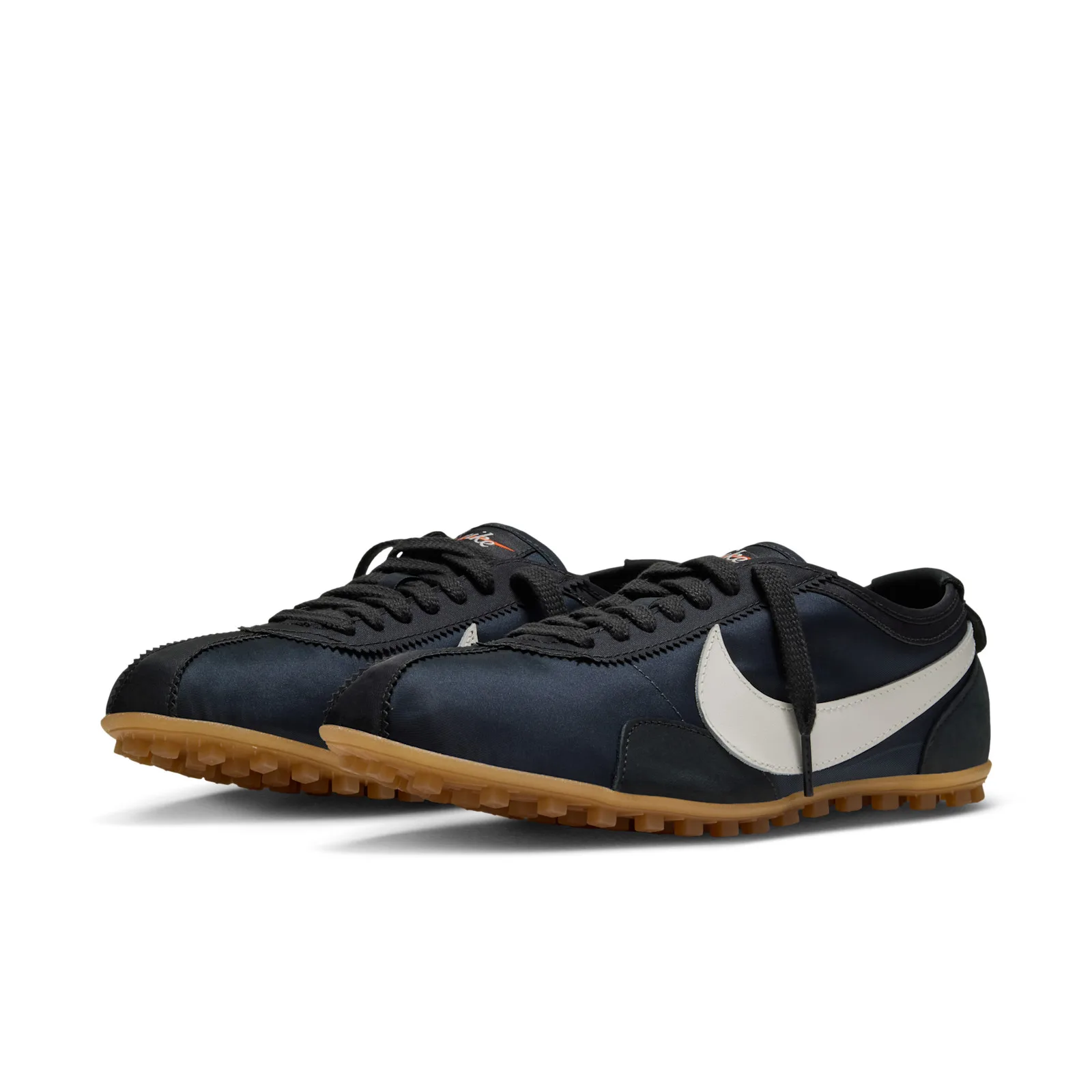Front three-quarter pair view, off-white swooshes, black laces, gum soles, Off Noir