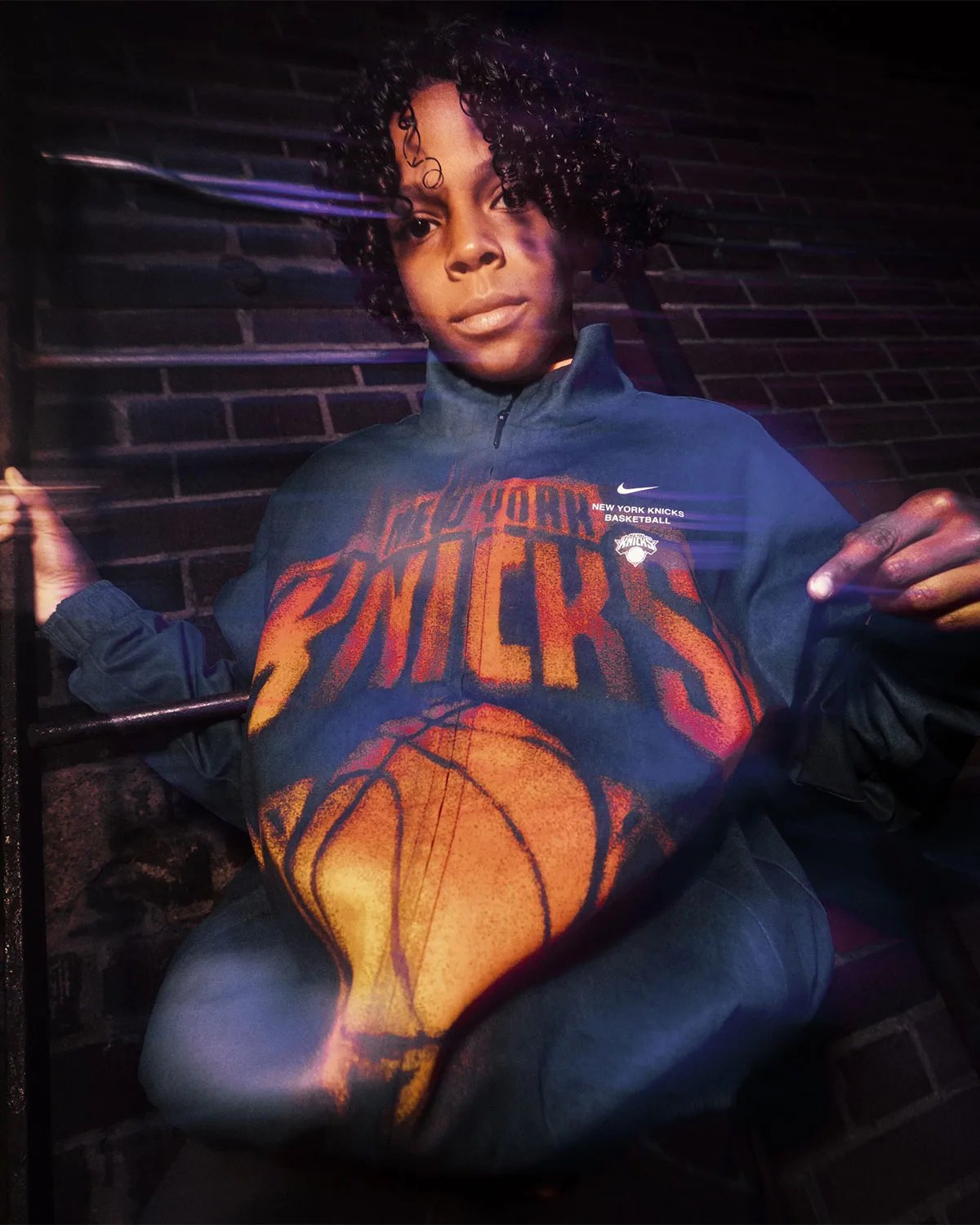 close-up on-body, navy jacket with orange spray-paint New York Knicks graphic, Standard Issue Collection