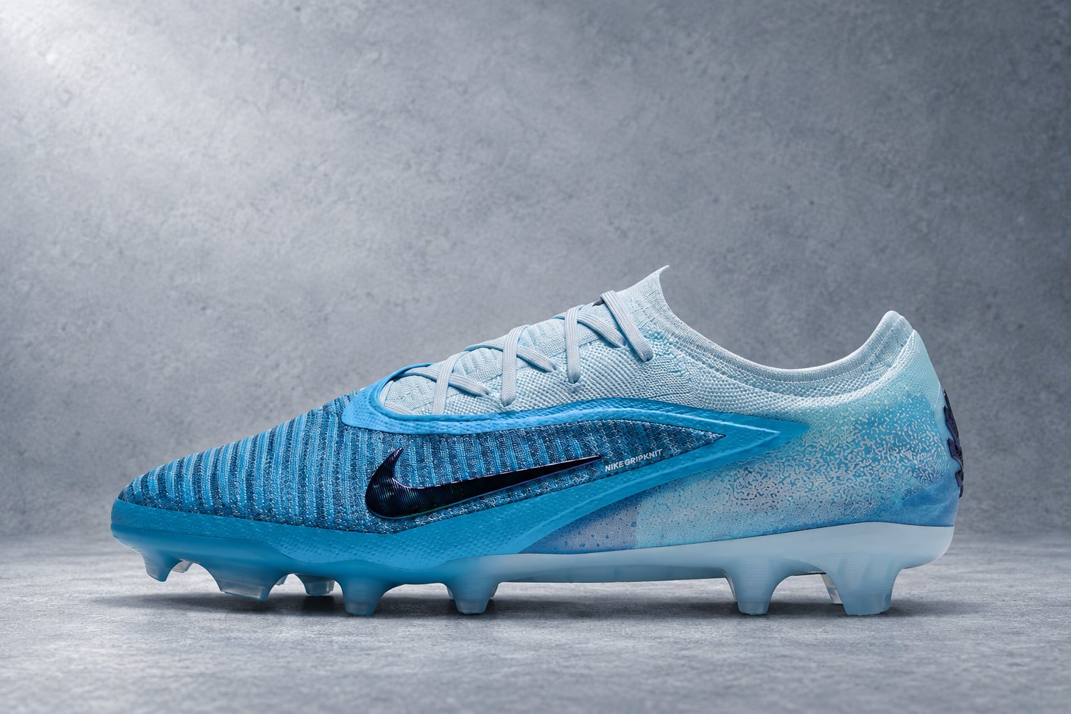 lateral view, blue gradient upper with dark swoosh, studded sole, grey backdrop, Nike Phantom 6 Low Elite “Baltic Blue”