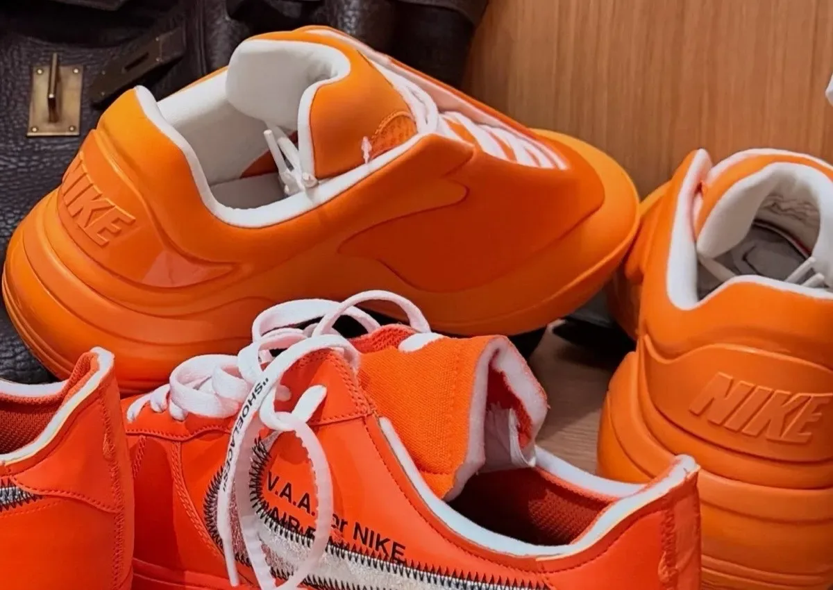 close-up heel view of orange shoes with white laces and NIKE embossed midsole, Nike Shai 001