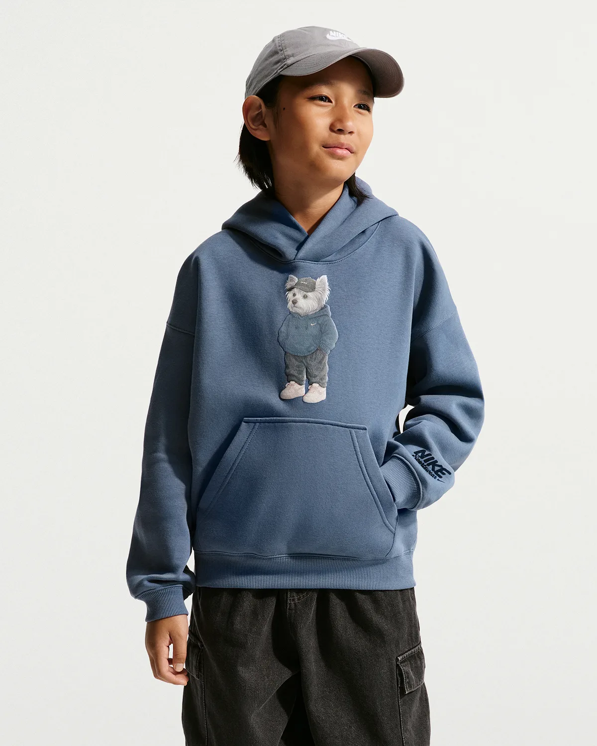 on-foot, kid in grey cap and blue hoodie with dog graphic on chest, Shoe Dog