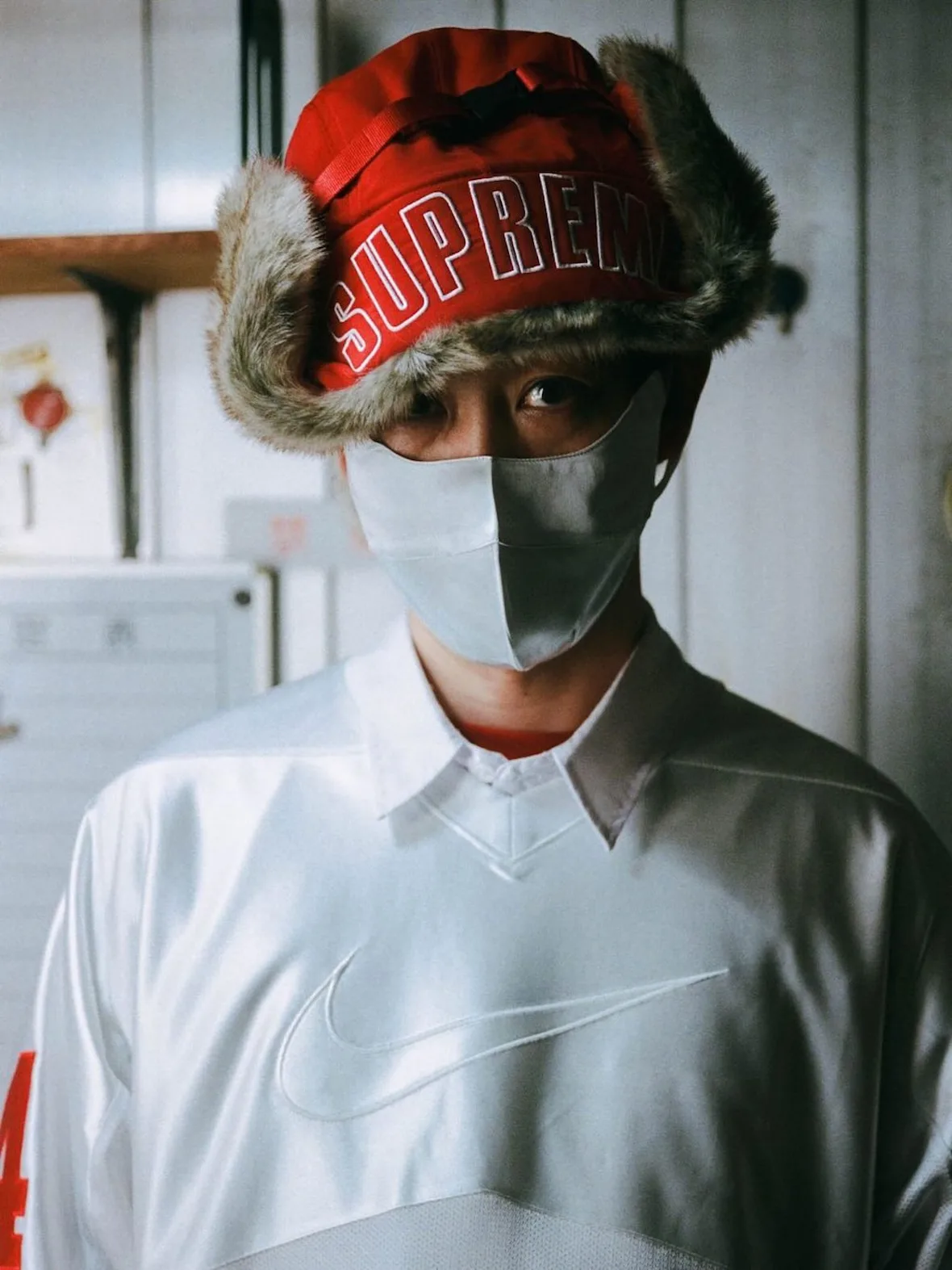 close-up, red fur trapper hat with Supreme text, grey mask, silver Nike jersey, Fall 2026 Collection