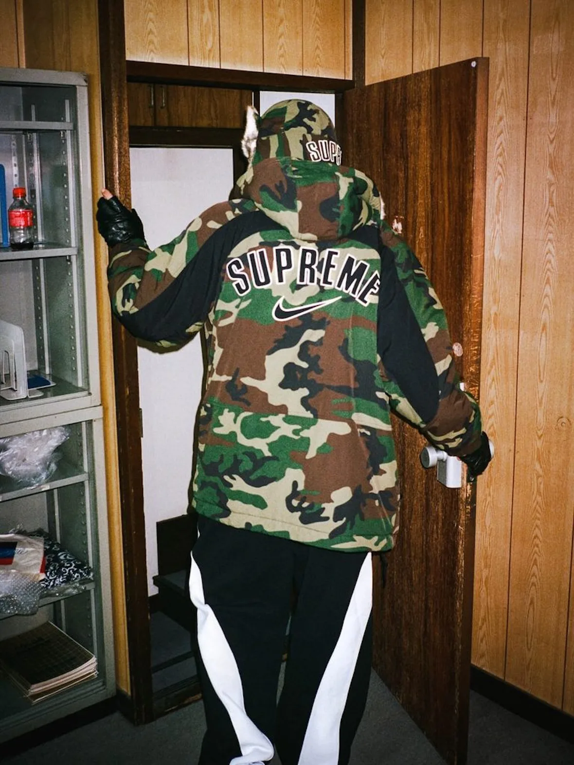 back view, camo jacket with fur-trim hood, Supreme arch logo and Nike swoosh, Fall 2026 Collection