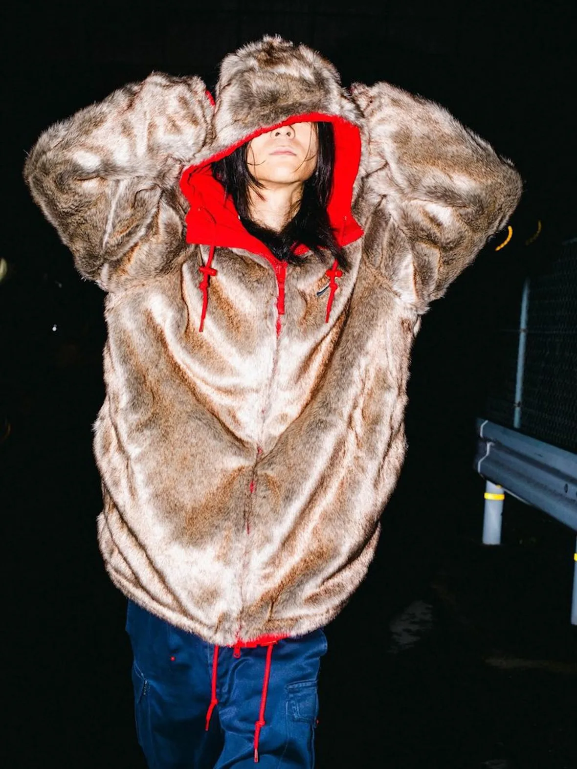 front view, tan faux-fur jacket with red hood lining and red zip, navy cargo pants, Fall 2026 Collection