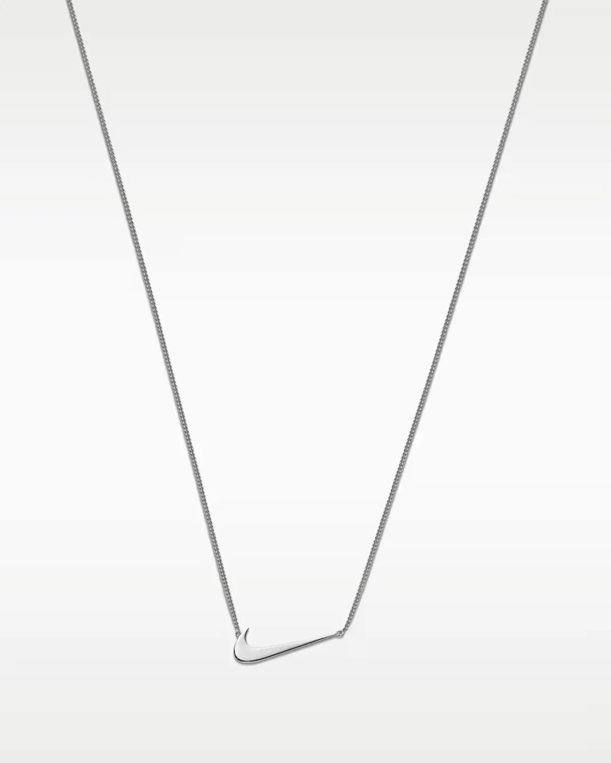 silver swoosh pendant necklace hanging on thin chain against light grey backdrop, Swoosh Jewelry Collection