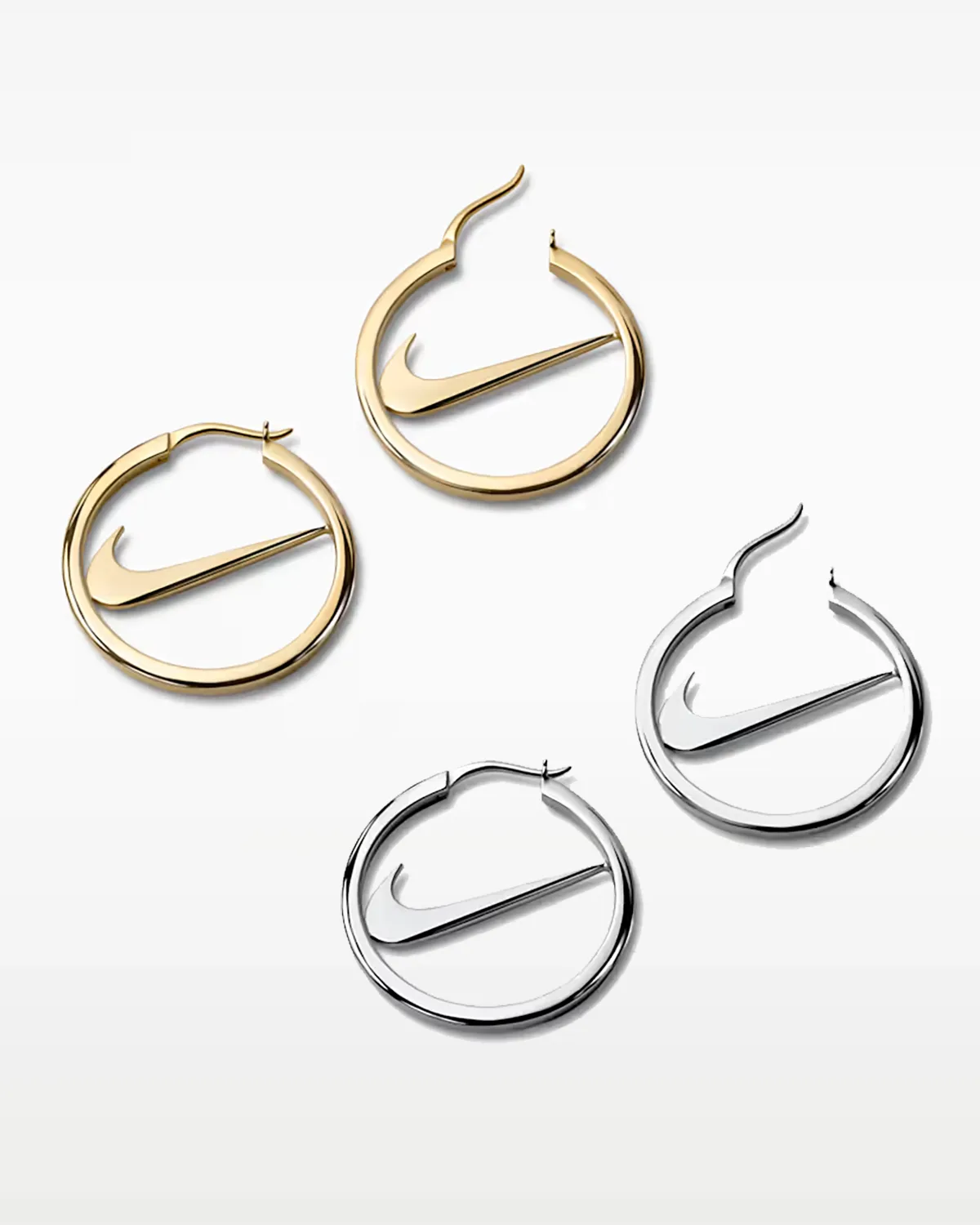 four swoosh hoop earrings laid flat, two gold pairs and two silver pairs, Swoosh Jewelry Collection