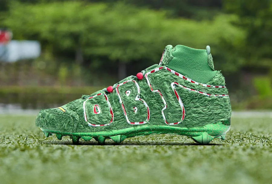 lateral view, green fuzzy turf-textured upper with dashed 'OBJ' outline, red lace pods, OBJ Uptempo Cleat