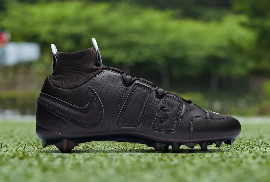 lateral view, all-black tonal upper with '13' panel, white lace tips, OBJ Uptempo Cleat