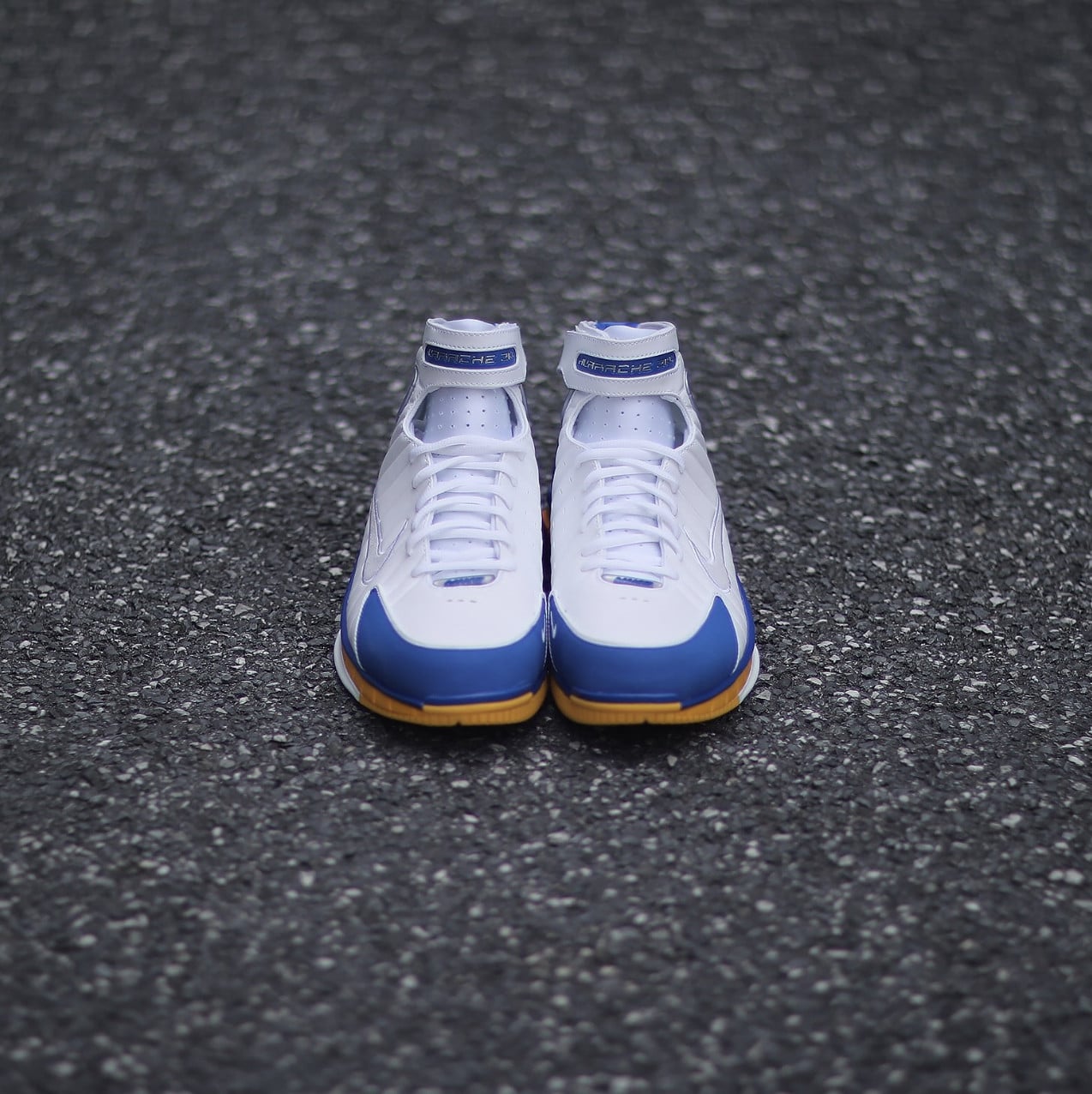 front-on pair view, white toe boxes with blue overlays and yellow sole edges visible, Zoom Huarache 2K4