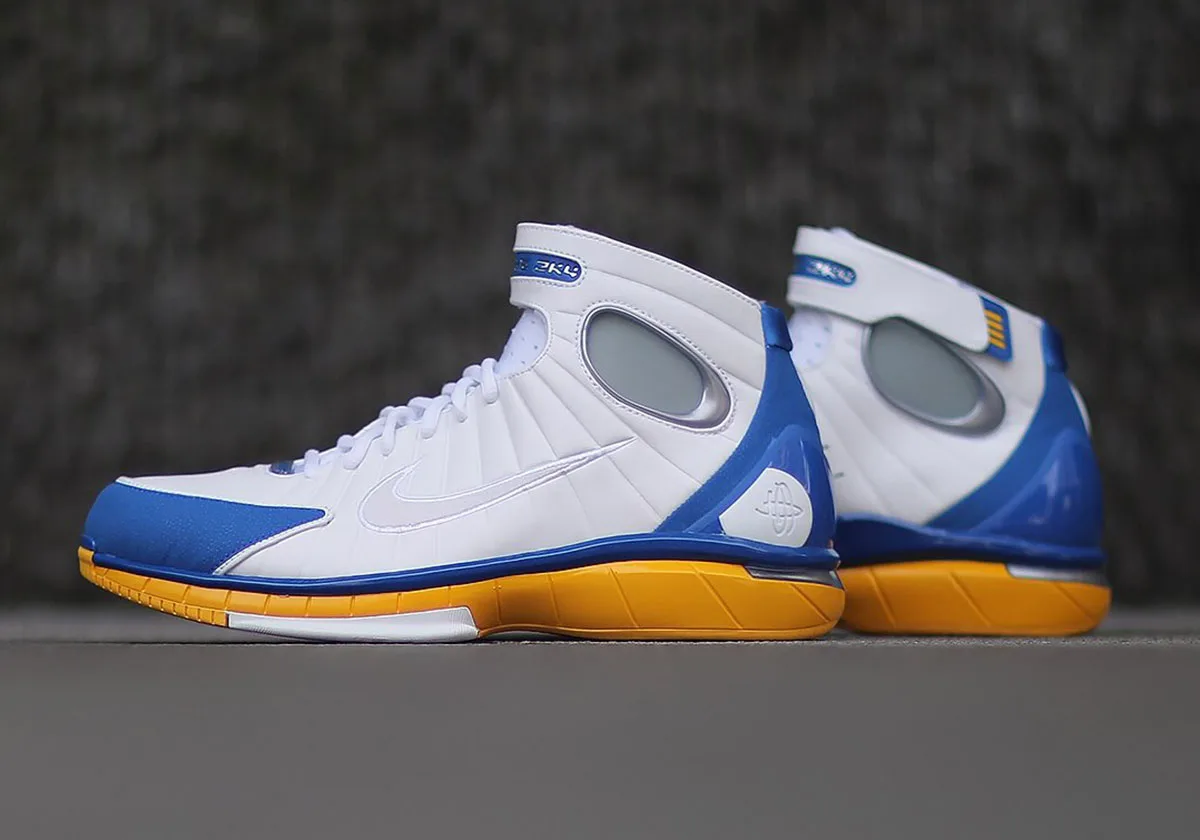 lateral pair view, white upper with blue toe and heel, yellow midsole, textured backdrop, Nike Zoom Huarache 2K4