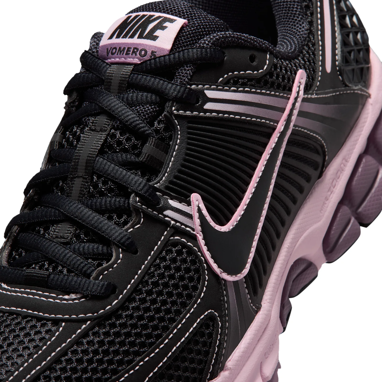 close-up of tongue tag reading Nike Vomero 5 in black text on pink, Black/Pink Foam